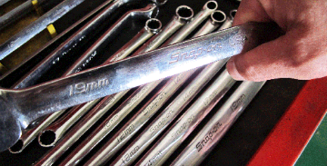 スパナをもつ手